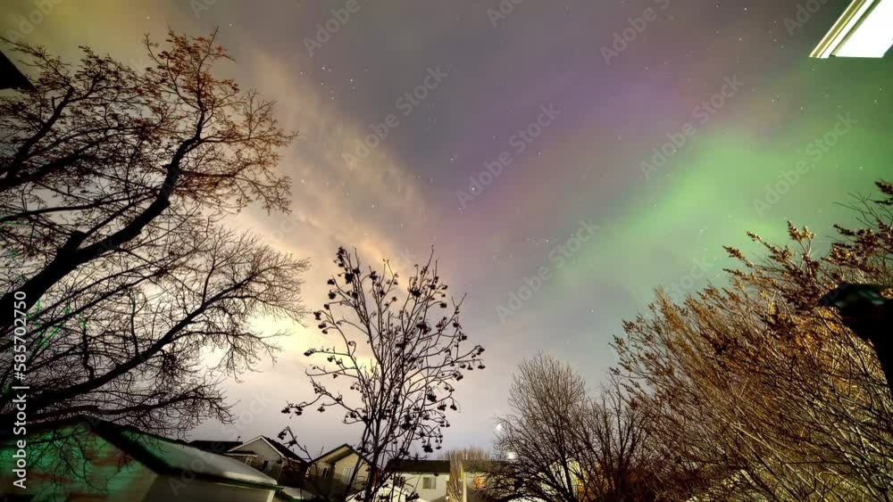 A neighbourhood community at night with auroras or polar lights, a natural light display dynamic patterns of brilliant lights that appear as curtains, rays, spirals, or dynamic flickers.