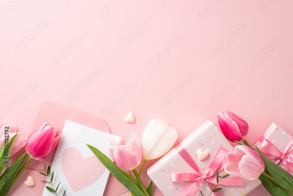 Mother's Day celebration concept. Top view photo of gift boxes with bows envelope with postcard fresh flowers tulips and small hearts on isolated pastel pink background with blank space - obrazy, fototapety, plakaty 