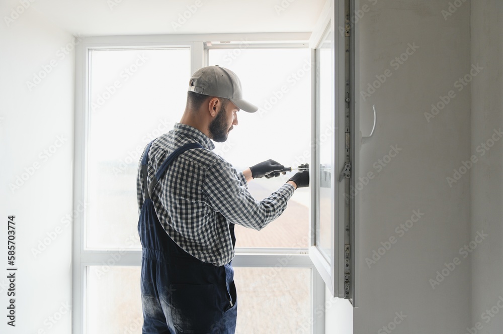 Construction worker installing window in house