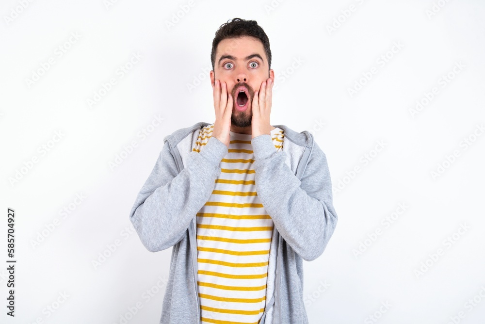 Scared terrified Young caucasian mán wearing trendy clothes over white background shocked with prices at shop, People and human emotions concept Scared terrified Young caucasian mán wearing trendy clothes over white background shocked with prices at shop, People and human emotions concept