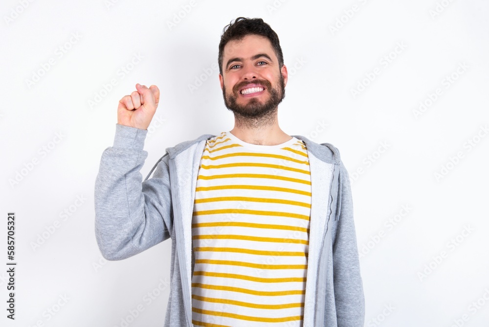 Young caucasian mán wearing trendy clothes over white background pointing up with fingers number ten in Chinese sign language Shi Young caucasian mán wearing trendy clothes over white background pointing up with fingers number ten in Chinese sign language Shi