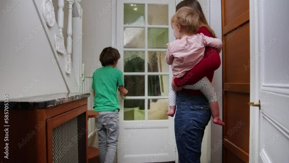 Mom open door for father bringing Christmas tree