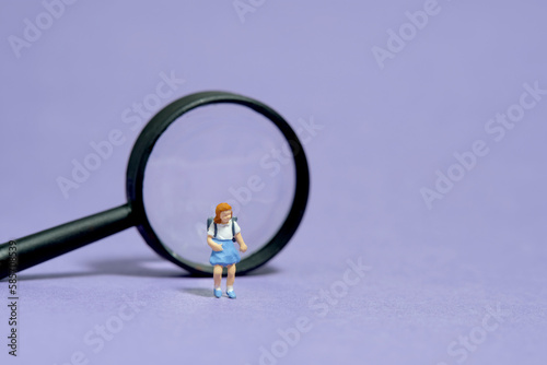 Wallpaper Mural Miniature people toy figure photography. Children curiosity concept. A girl kindergarten student standing in front of black magnifier glass. Isolated on purple background. Torontodigital.ca