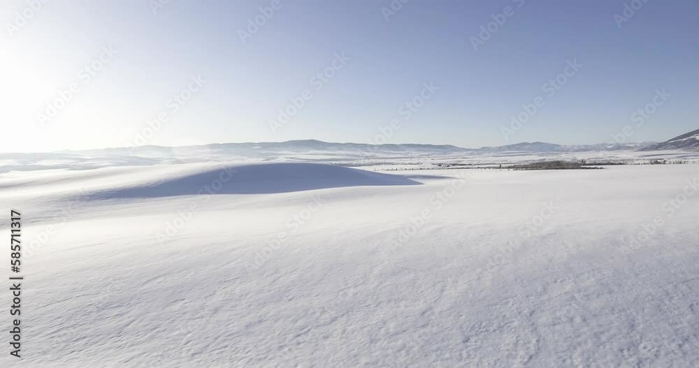 open snowy landscape aerial with rolling hill in distance open snowy landscape aerial with rolling hill in distance