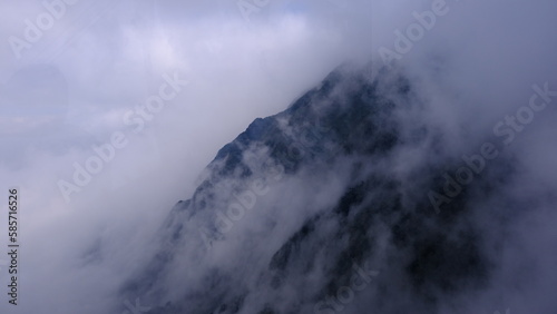 Spectacular view top of mountain surrounded with clouds. Amazing peak in clouds.