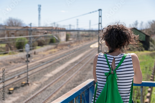 Thoughtful woman looking at the train tracks