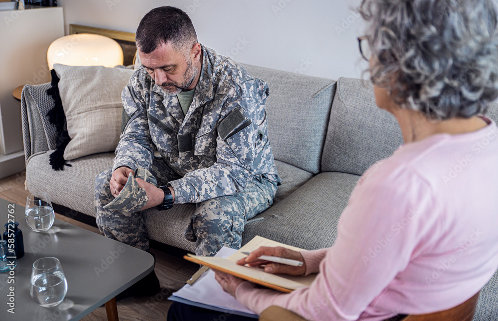 Veteran soldier having therapy meeting with senior female psychologist. Veteran soldier having therapy meeting with senior female psychologist.