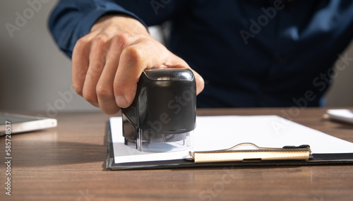 Businessman puts a stamp on the documents in the office.