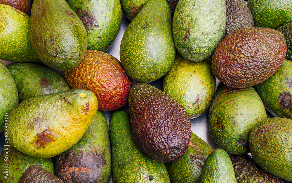 Ripe juicy avocados top view closeup, for sale at the local market. Fresh fruit colorful background. Ripe juicy avocados top view closeup, for sale at the local market. Fresh fruit colorful background.