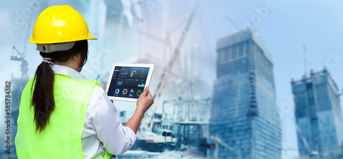 Smart Construction Project management system concept.Hands using digital tablet with Construction Management Software on blurred construction site as background