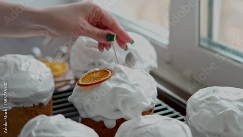 A Caucasian Woman's Hand decoretes freshly cooked Easter Cakes. Cooking homemade traditional Easter Cakes photo