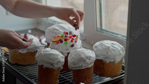 A Caucasian Woman's Hand decoretes freshly cooked Easter Cakes. Cooking homemade traditional Easter Cakes photo