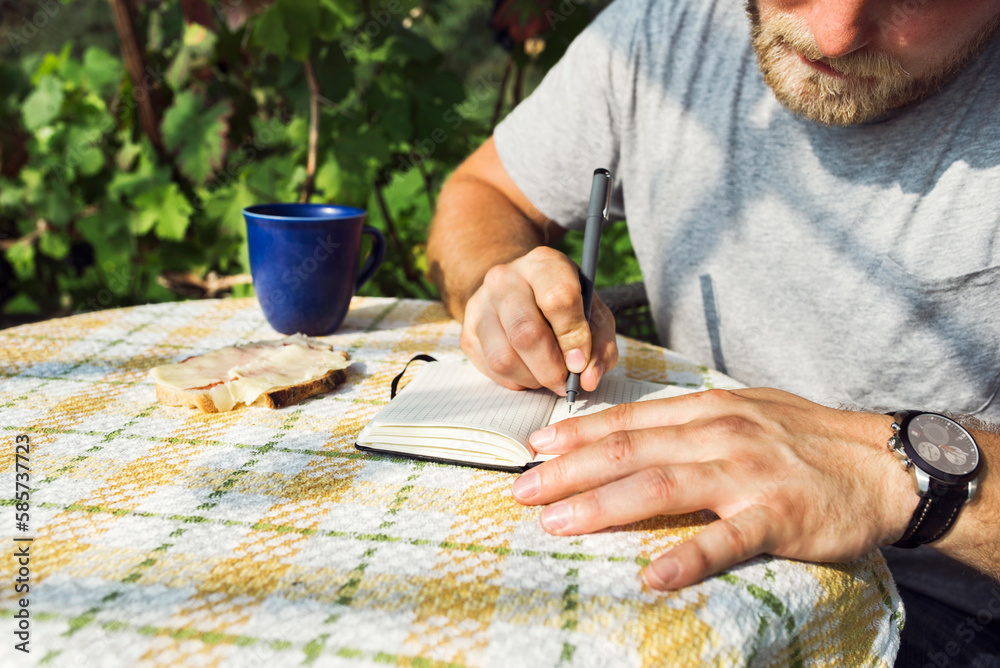 Man taking notes on table Man taking notes on table