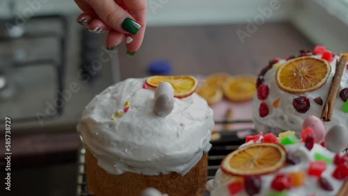 Close-up of a Caucasian Woman's Hand decoretes freshly cooked Easter Cakes. Cooking homemade traditional Easter Cakes photo