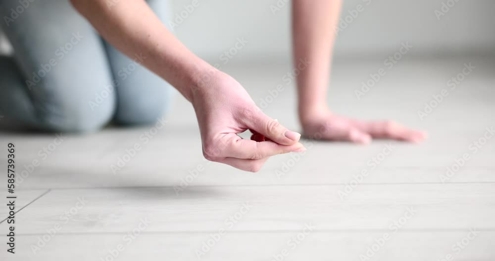 Housewife collects dust on laminate floor with finger Housewife collects dust on laminate floor with finger