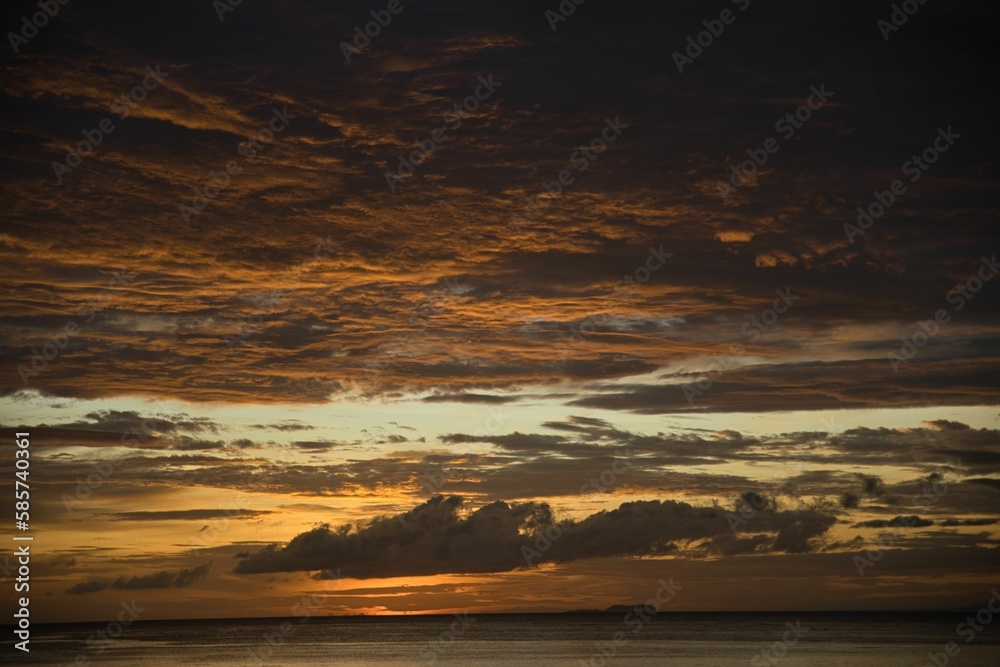 Picturesque sunset on the beach of Siquijor in the Philippines, the whole sky glows in golden yellow color.