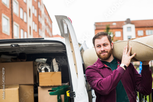 Man loading carpet into rental car