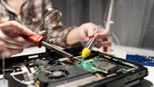 an electrical repairman solders a chip