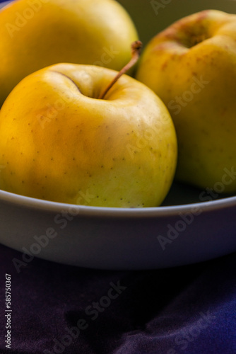 close up yellow apples in a bowl