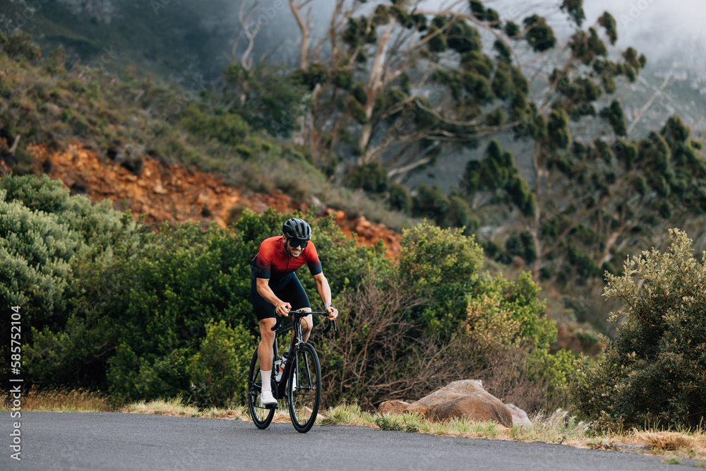 Young male cyclist practicing in wild terrain. Professional triathlete riding road bike.