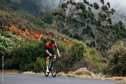 Young male cyclist practicing in wild terrain. Professional triathlete riding road bike. © Artem Varnitsin