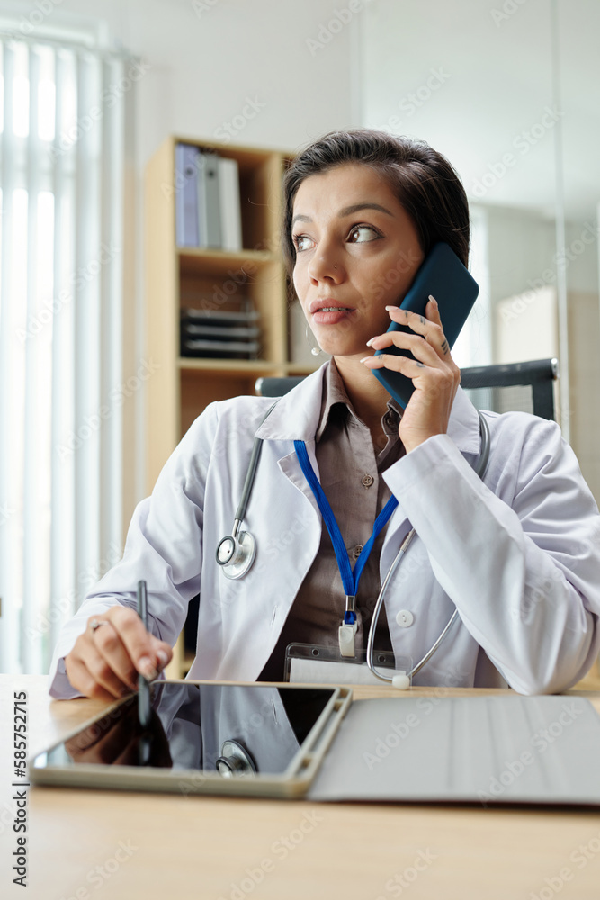 Female doctor talking on phone with client Female doctor talking on phone with client