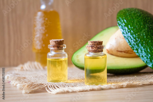 Avocado and avocado oil on wooden background. Selective focus