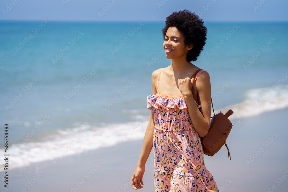 Young ethnic female spending summer vacation on seashore Young ethnic female spending summer vacation on seashore