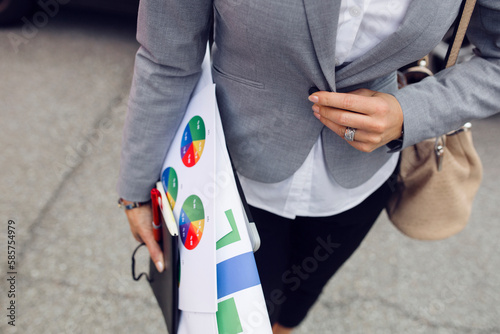 Mid section of woman carrying printouts photo