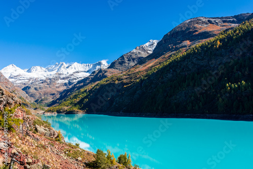 Autumnal landscape of the Lake Place Moulin, an artificial glacial lake with turquoise water in the italian Alps, on the border with Switzerland