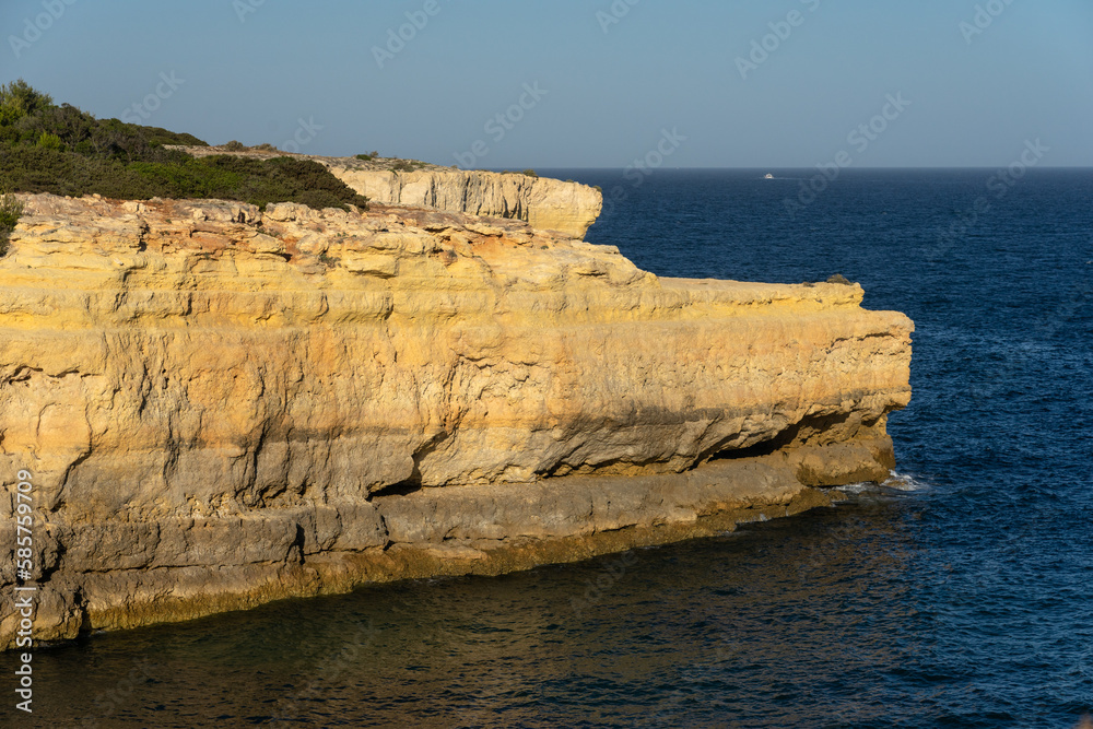 Landscape of Albandeira beach, cliffs, and natural arch in the Algave region at sunset. Portugal.