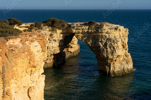 Landscape of Albandeira beach, cliffs, and natural arch in the Algave region at sunset. Portugal.