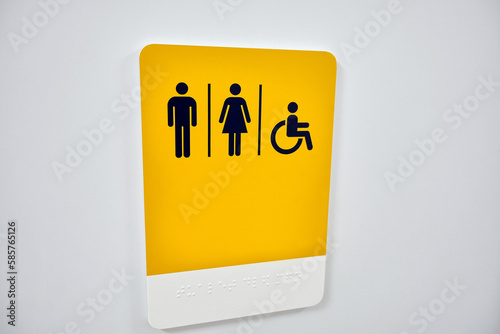 A sign indicating male, female, and a person with physical disabilities. Inscription in braille.