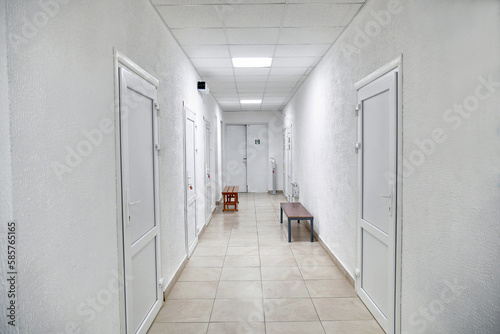 Corridor with white walls, white plastic doors and communications. © Vasyl