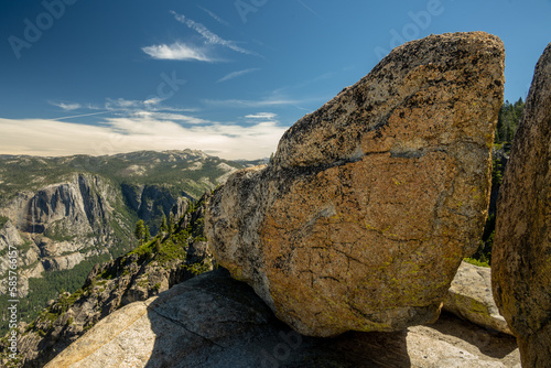 Glacial Rocks Stand On The Edge Of Taft Point Overlooking Yosemite Falls In The Distance