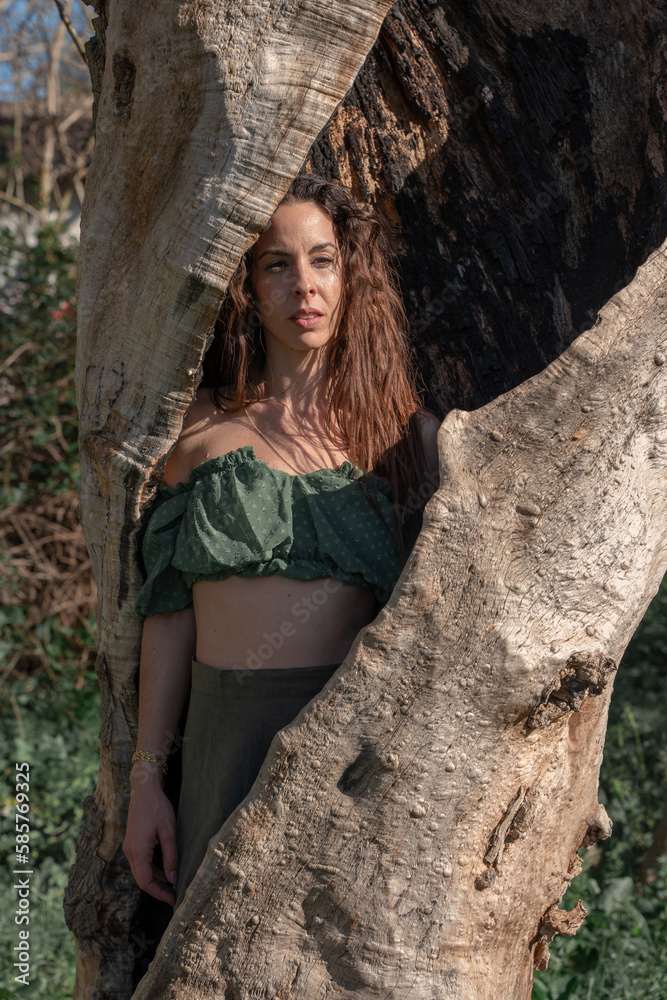 Tree-trunk sanctuary: a woman mystic enveloped in the embrace of the sacred tree. Concept of spirituality, mysticism and a deep and ancestral connection with nature. Tree-trunk sanctuary: a woman mystic enveloped in the embrace of the sacred tree. Concept of spirituality, mysticism and a deep and ancestral connection with nature.