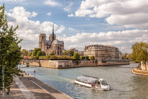 Notre Dame cathedral with tourist boat on Seine during spring time in Paris, France