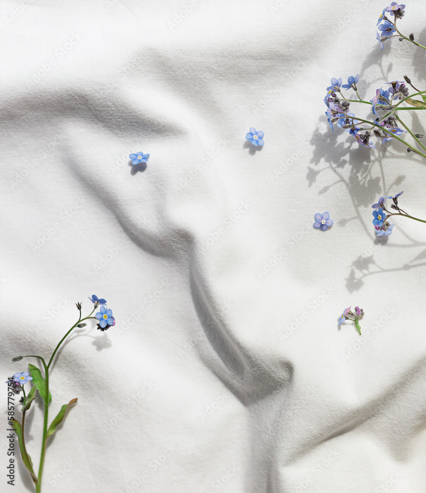 White organic cotton blanket with forget-me-not flowers. Copy space White organic cotton blanket with forget-me-not flowers. Copy space