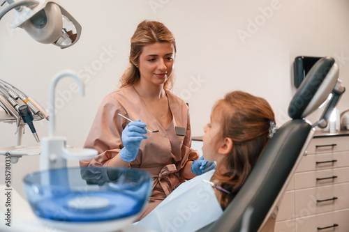 Female doctor is working with little girl. In the stomatological cabinet
