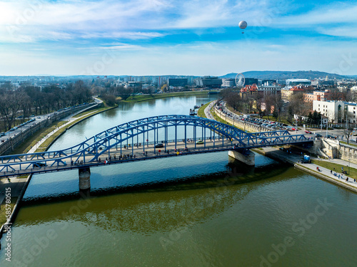 Krakow  Poland. Blue Pilsudski tied-arc bridge  observation and tourist balloon over Vistula River and far view of a Ferris wheel