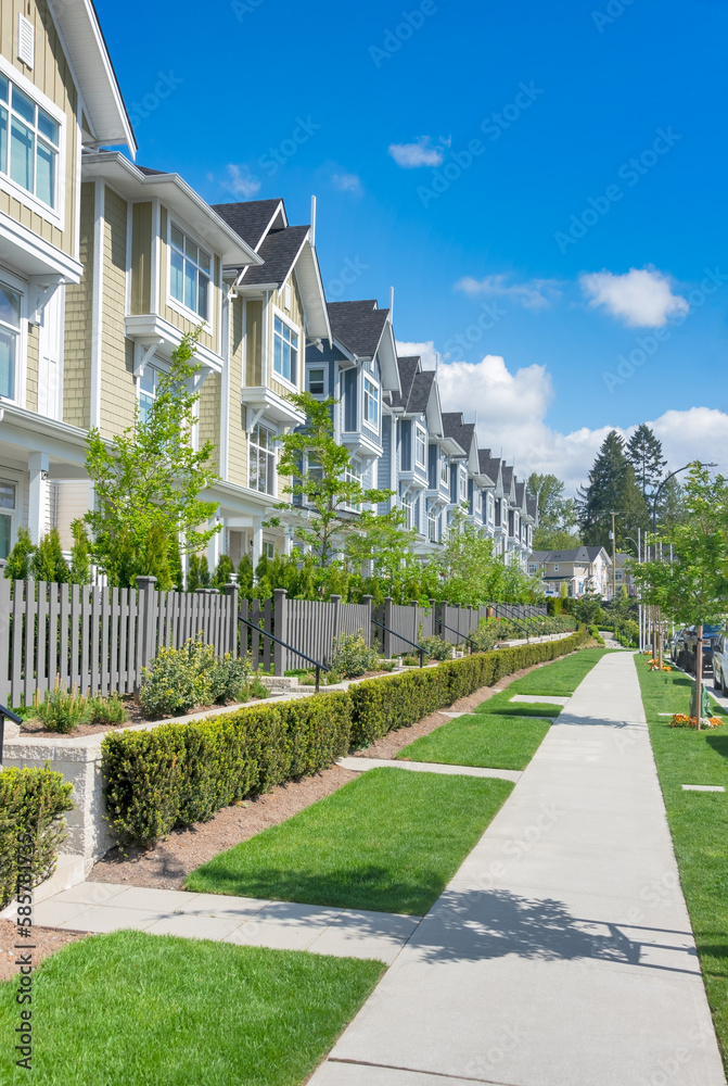 Paved walkway in front of residential townhouses on a bright sunny day