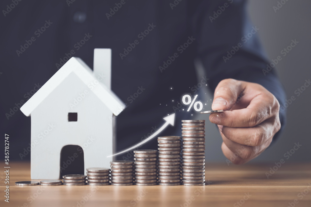 Interest for home, Interest rate for housing, Business and Financial for residence, Money saving for home concept. Man increasing coin stacked and house model on the wooden table. - obrazy, fototapety, plakaty 