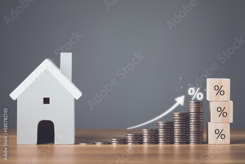Bank interest for home, Interest rate for housing, Business and Financial for residence, Money saving for home concept. Increasing coin stacked and house model on the wooden table.