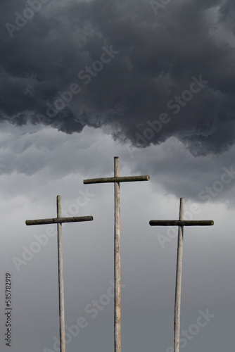 Three crosses with ominous dark clouds above photo