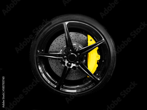 Car alloy wheel and tyre isolated on black background. New alloy wheel with tire and yellow carbon ceramic brakes. Alloy rim isolated. Car wheel disc. Car spare parts..