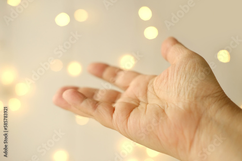 close-up female hand on blurred background with bokeh, gesticulation symbol, allergic itch, concept palm divination, health and predisposition to diseases, scientific research, basis for designer
