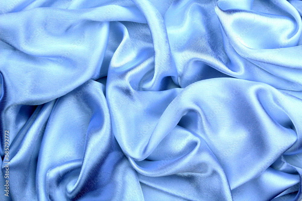 Obraz premium Satin beautiful blue silk fabric lies with drapery. 