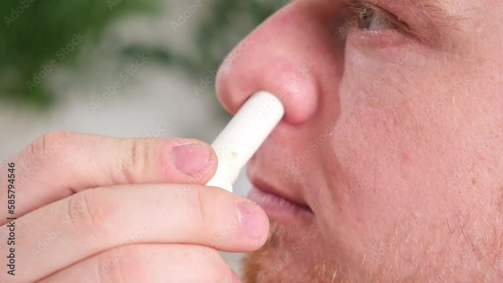 Adult man uses nasal stick inhaler to smell for relieve dizzy and faint ...