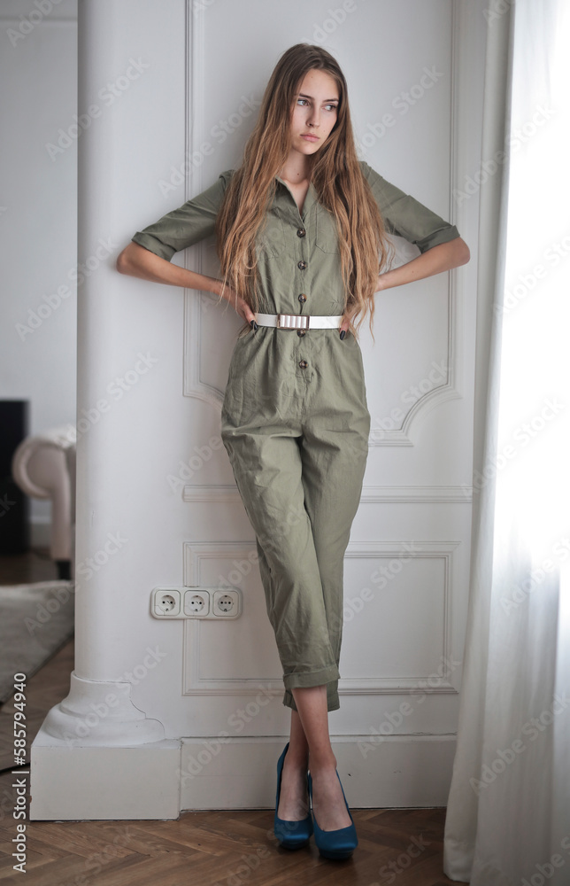 young model standing leaning against a wall