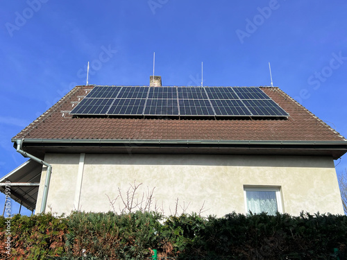 Home solar panel. Alternative energy is used for heating and water heating. Eco-friendly alternative energy for house. Residential family house suburban. Brown tile roof of home with solar panels. 